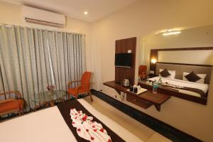 a hotel room with a bed and a table and chairs at Nexstay Hotel Calicut Gate in Kozhikode +24 photos