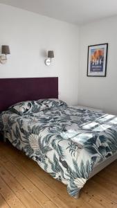 Un dormitorio con una cama con un edredón azul y blanco. en Petite maison plage et port de plaisance à pied, en Dives-sur-Mer