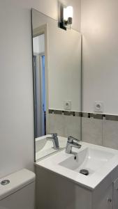 Un baño con un lavabo blanco y un espejo. en Petite maison plage et port de plaisance à pied, en Dives-sur-Mer