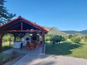 a gazebo with a table and a grill at Cabana Gap House in Colţeşti