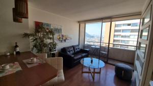 a living room with a couch and a table at Apartamento Pet-Friendly, Piscina, Vista Cerro San Cristobal, Santiago in Santiago
