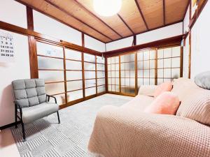 a living room with a couch and a chair at Tokyo Nukumori Lodge in Tokyo