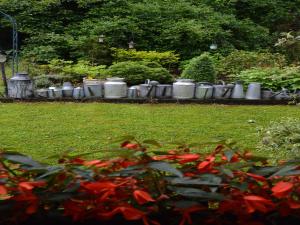 a garden with a bunch of pots and red flowers at Peaceful Garden Stay, Malmedy in Malmedy +32 photos
