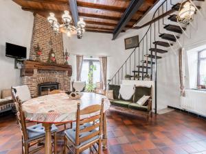 a dining room with a table and a fireplace at Charming Oombergen Mill Retreat in Zottegem