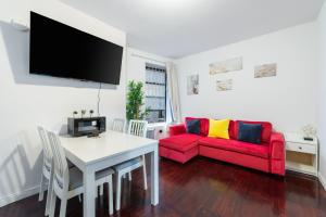 a living room with a red couch and a table at 2 BD Cozy Home in Manhattan Valley in New York