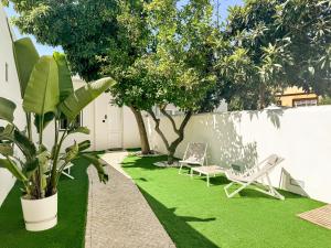 a yard with two lawn chairs and a tree at Dear Faro - Guest House in Faro +26 photos