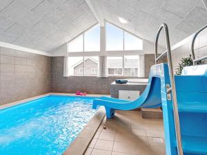 a swimming pool with a blue slide in a room at 5 star holiday home in Grenaa in Grenå