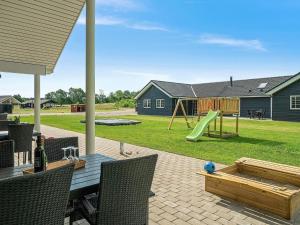 a patio with a table and a playground at 18 person holiday home in Grenaa in Grenå
