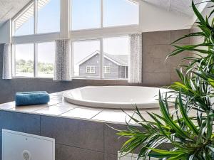 a large bath tub in a bathroom with windows at 5 star holiday home in Grenaa in Grenå
