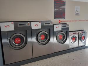 a row of washing machines in a laundry room at Chambres Zola in Nantes