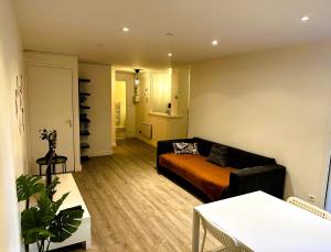 a living room with a couch and a table at Eugène - Elégance & Confort in Reims