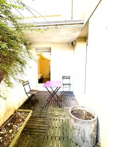 a patio with two chairs and a table on a building at Eugène - Elégance & Confort in Reims