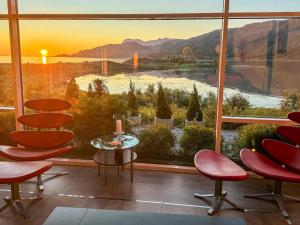 Habitación con ventana grande con sillas y mesa. en 6 person holiday home in Inndyr, en Inndyr