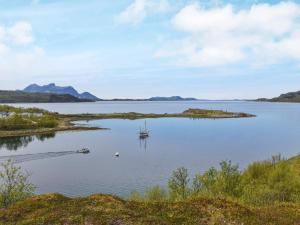una isla con un barco en un gran cuerpo de agua en 6 person holiday home in Inndyr, en Inndyr