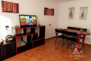 a living room with a table and a tv and a dining table at Casa La Abuela 1982 in La Iruela