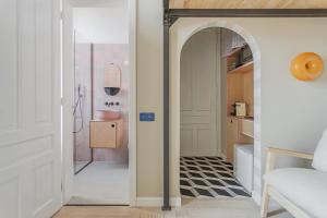 a hallway with an archway leading to a bathroom at Adorján Apartments - Sunset Studio in Oradea