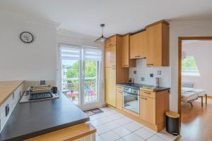 オベルネにあるChez Carine - Idéal famille, Balcon, Netflixの木製のキャビネットとカウンタートップを備えたキッチン