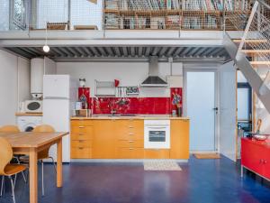 an open kitchen with orange cabinets and a wooden table at Treehouse in Galicia near Silgar Beach in Sanxenxo