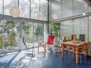 a living room with a table and chairs and windows at Treehouse in Galicia near Silgar Beach in Sanxenxo
