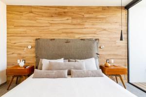 a bedroom with a white bed and wooden wall at Rooftop & Private Pool Property Family in Guadalajara
