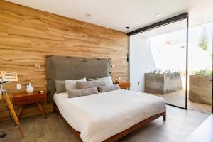 a bedroom with a large bed and a wooden wall at Rooftop & Private Pool Property Family in Guadalajara