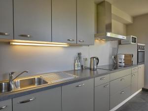 a kitchen with white cabinets and a sink at Ovifat Sauna Escape, Waimes in Ovifat