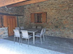 ein Tisch und Stühle auf einer Terrasse mit einer Steinmauer in der Unterkunft Casa Dos Avós in Bragança + 17 Fotos