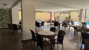 a dining room with tables and chairs and windows at Splendor Thermas in Caldas Novas