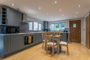 a kitchen with a wooden table and a dining room at Abbey Rectory - with private parking in Bath +30 photos