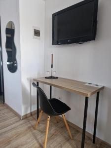 a desk with a chair and a television on a wall at Zen in Tălmaciu +28 photos