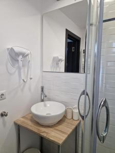 a white bathroom with a sink and a shower at Zen in Tălmaciu