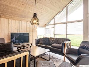 a living room with a couch and a tv at 5 star holiday home in Højslev in Sundstrup