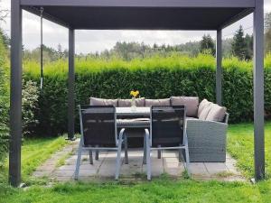 a table and chairs under a gazebo with a couch at 6 person holiday home in lyngdal-By Traum in Lyngdal