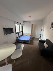 a room with a bed and a table and a couch at Apartment equipped with amenities ideal for two in Buenos Aires
