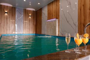 ein Swimmingpool mit Weingläsern auf einer Bar in der Unterkunft Pensiunea Alpin SPA in Ranca + 28 Fotos