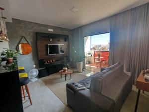a living room with a couch and a television at Apê aconchegante in Franca