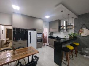 a kitchen with a table and a white refrigerator at Apê aconchegante in Franca