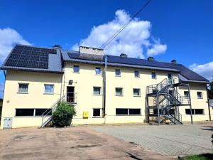 a white building with solar panels on the roof at Sezam Smart Lock Kraczkowa in Kraczkowa