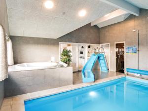 a large bathroom with a swimming pool and a slide at 18 person holiday home in Ringkøbing in Ringkøbing