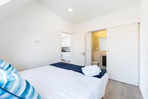 a white bedroom with a bed and a window at GuestReady - Modern Aveiro nook in Aveiro