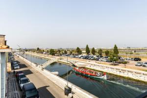 a river with cars and a bridge with a boat at GuestReady - Modern Aveiro nook in Aveiro