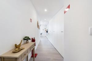 a hallway with white walls and a wooden table at GuestReady - Modern Aveiro nook in Aveiro +17 photos