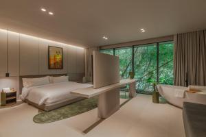 a bedroom with a bed and a large window at Wake BioHotel in Medellín