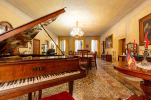 a living room with a piano and a dining room at Villa Nani Mocenigo, Golin in Dolo
