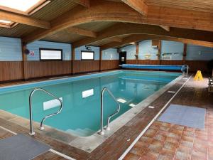 Una gran piscina con agua azul en un edificio. en Oakwood 1, en Rousdon