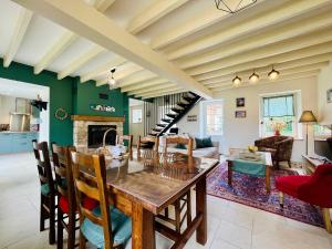 a kitchen and living room with a wooden table and chairs at Les Chatons - Gite au coeur de la campagne in Fresville