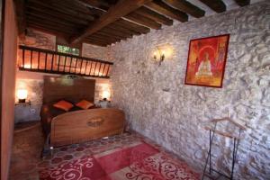ein Schlafzimmer mit einem Bett in einer Steinmauer in der Unterkunft Moulin de Moulignon B&B in Messy + 34 Fotos