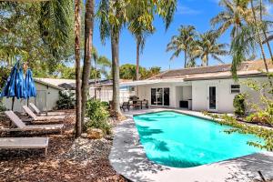 ein Swimmingpool vor einem Haus mit Palmen in der Unterkunft Private Jungle Pool Home - Arcade Games & Pool in Fort Lauderdale