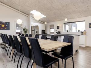 a conference room with a wooden table and black chairs at 5 star holiday home in Væggerløse in Bøtø By