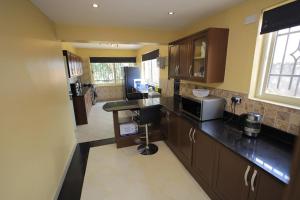 a kitchen with wooden cabinets and a counter top at Cosy, private and modern in Kampala